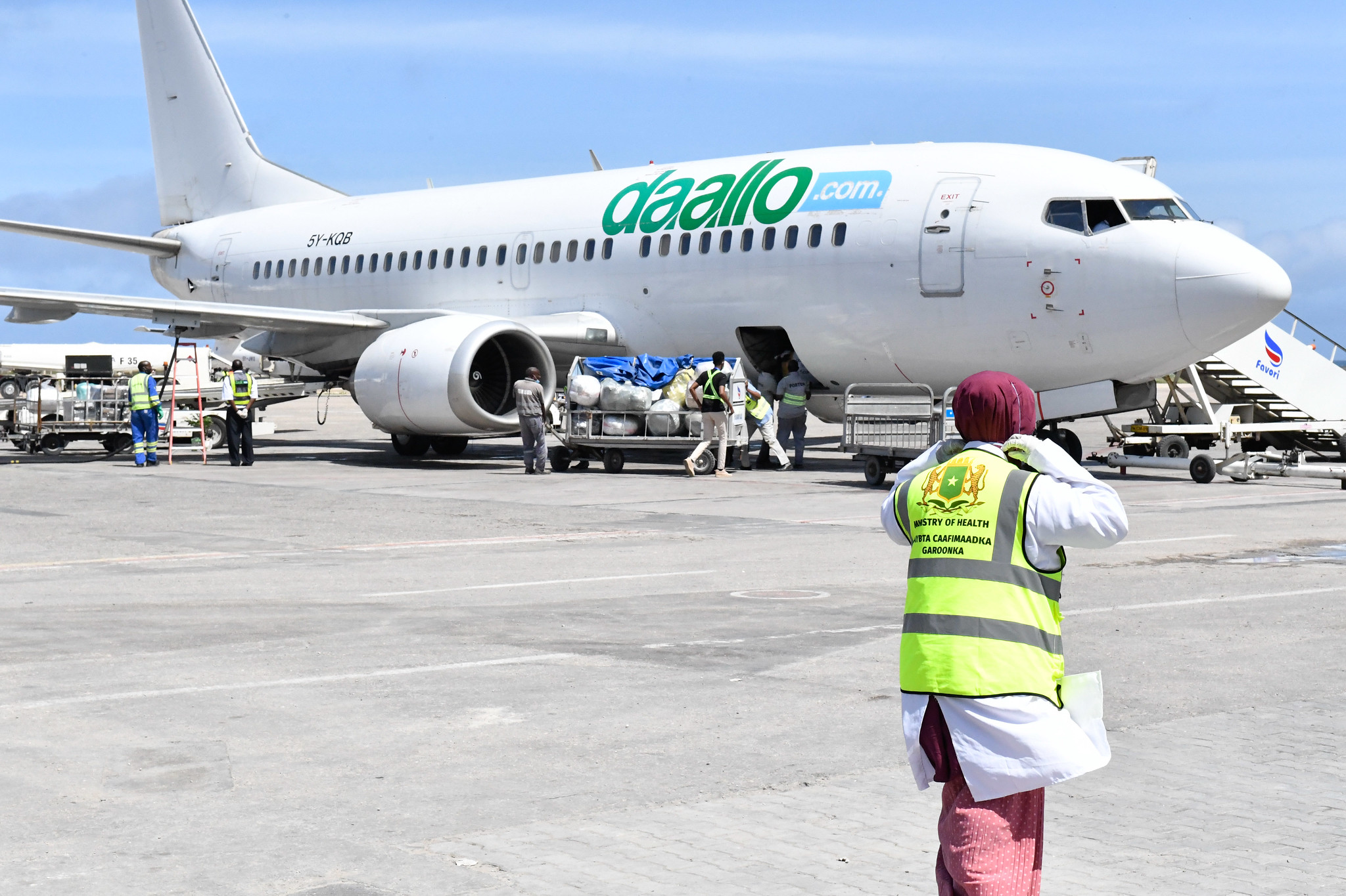 Baggage handlers offloading luggage from an airplane at Aden Abdulle Airport in Mogadishu, Somalia, on June 28, 2020. Photo by AMISOM