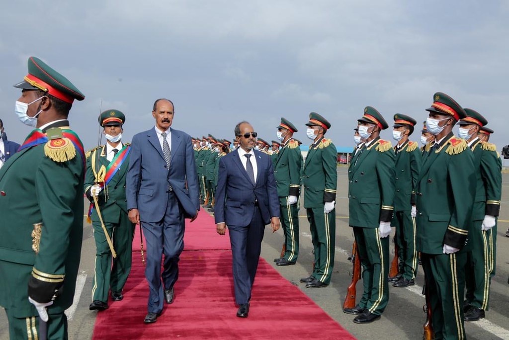 Somali President Hassan Sheikh Mohamud and Eritrean President Isaias Afwerki walking on a red carpet at Asmara Airport, flanked by Eritrean military personnel in green uniforms and ceremonial attire, on July 10, 2022. Photo by Villa Somalia