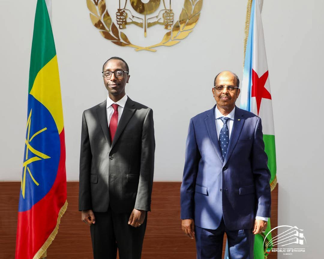 Ethiopia’s Foreign Minister, Dr. Gedion Timothewos, shakes hands with Djibouti’s Foreign Minister, Mahmoud Ali Youssouf, during an official visit in Djibouti. Both officials are smiling, symbolizing the strong diplomatic ties between their nations.