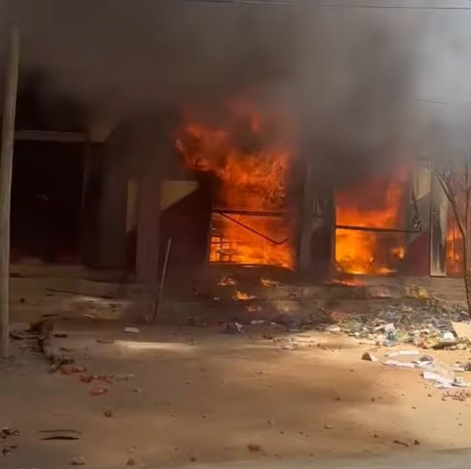 A building in Qabribayax, Ethiopia, engulfed in flames, with thick black smoke rising into the air. Debris and scattered trash are visible in front of the structure as the fire continues to spread.