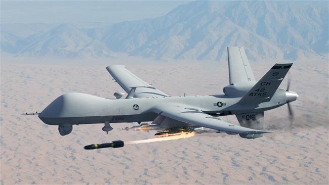 An unmanned aerial drone firing missiles while hovering over mountains.