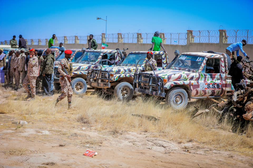 A military parade in Ceerigaabo, Somaliland, featuring soldiers in desert camouflage uniforms, red berets, and camouflaged military vehicles labeled "S.S.B."