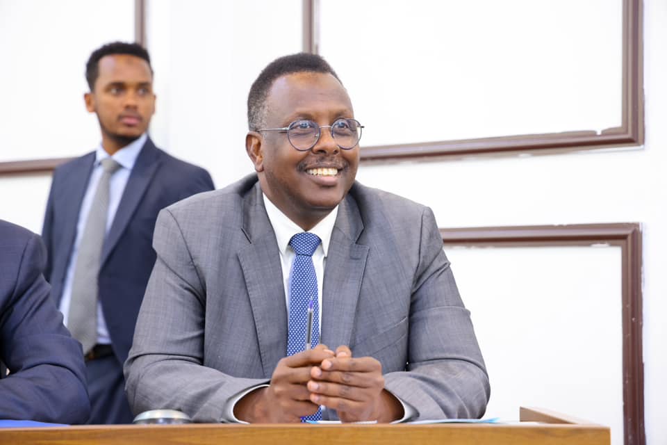 Somali Minister of Justice and Constitution, Hassan Macallin Mahmoud, smiling while seated at a conference.