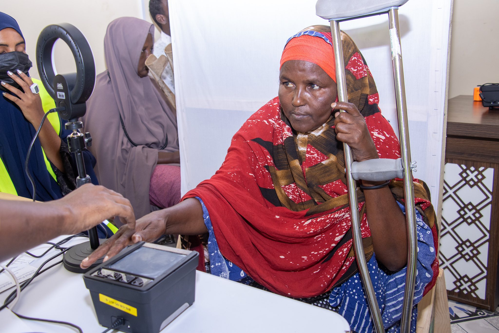 A disabled Somali woman registers her fingerprint during the voter registration process.