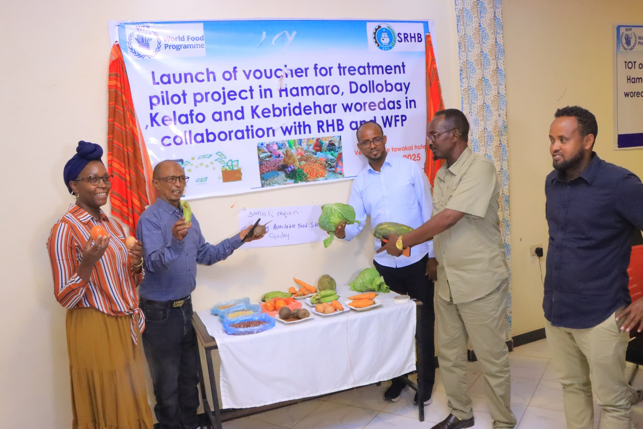 Officials and WFP staff display fresh produce during the launch of a nutrition pilot project in Goday, Somali Region.
