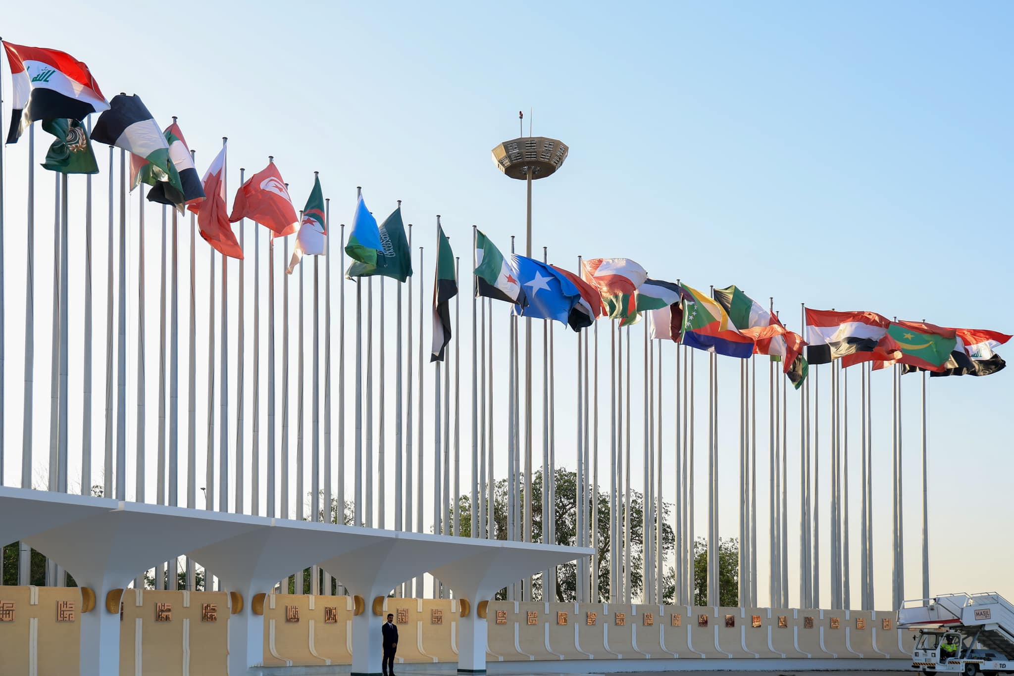 Flags of the member countries of the Arab League flying in an open area in Baghdad, Iraq.