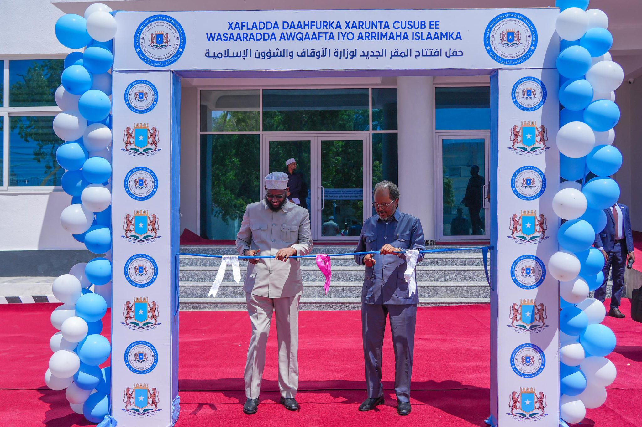 Somalia’s President Hassan Sheikh Mohamud and the Minister of Awqaf and Islamic Affairs cutting the ribbon during the inauguration of the ministry’s new headquarters.