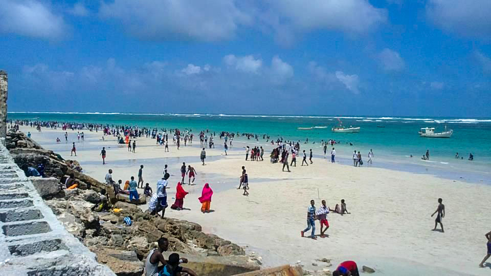 Fishing boats docked at the Somali coast with fishermen preparing for their daily catch amid calm seas.